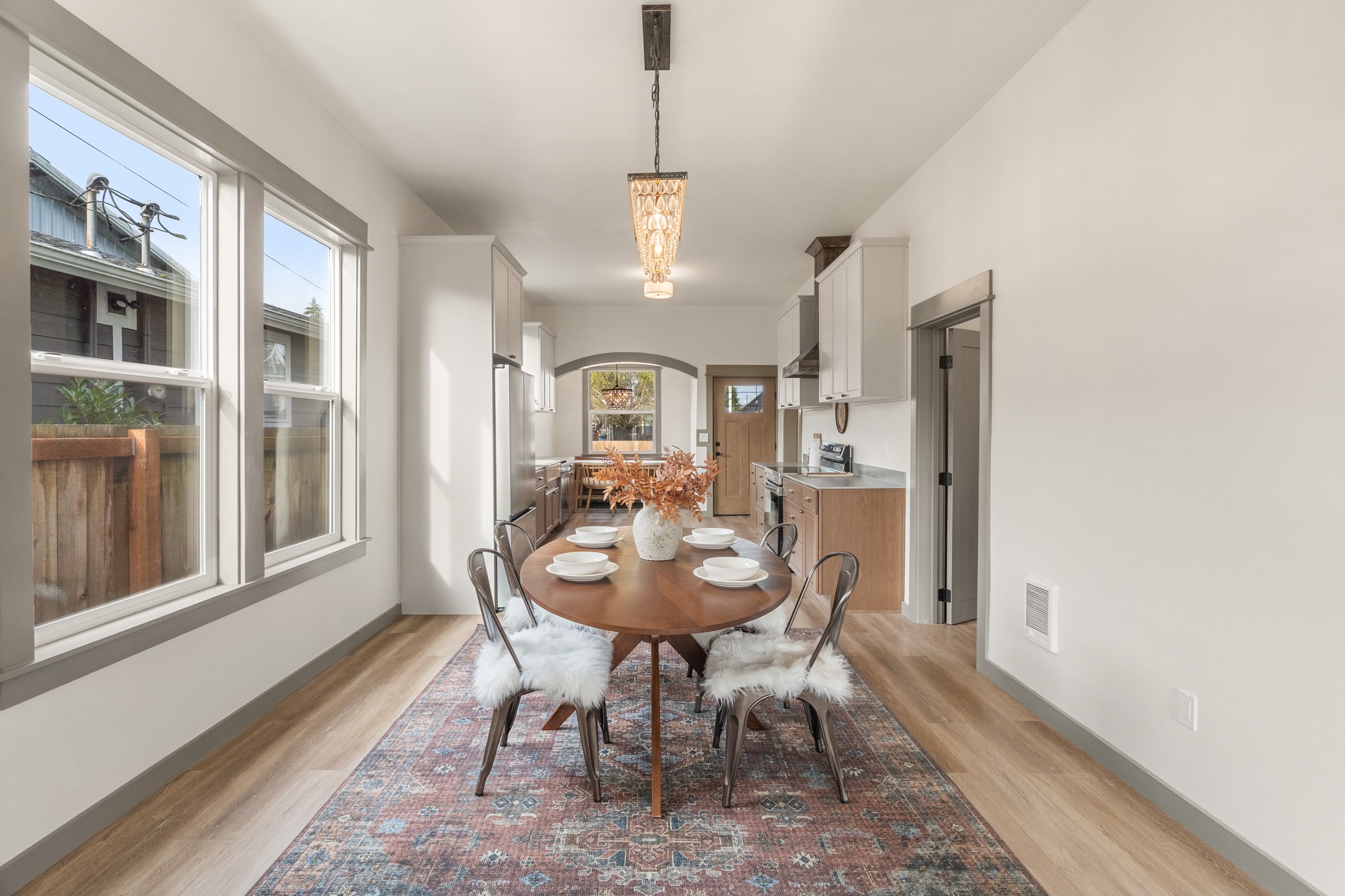 Eklund Ave — dining room with chandelier and two-tone kitchen beyond