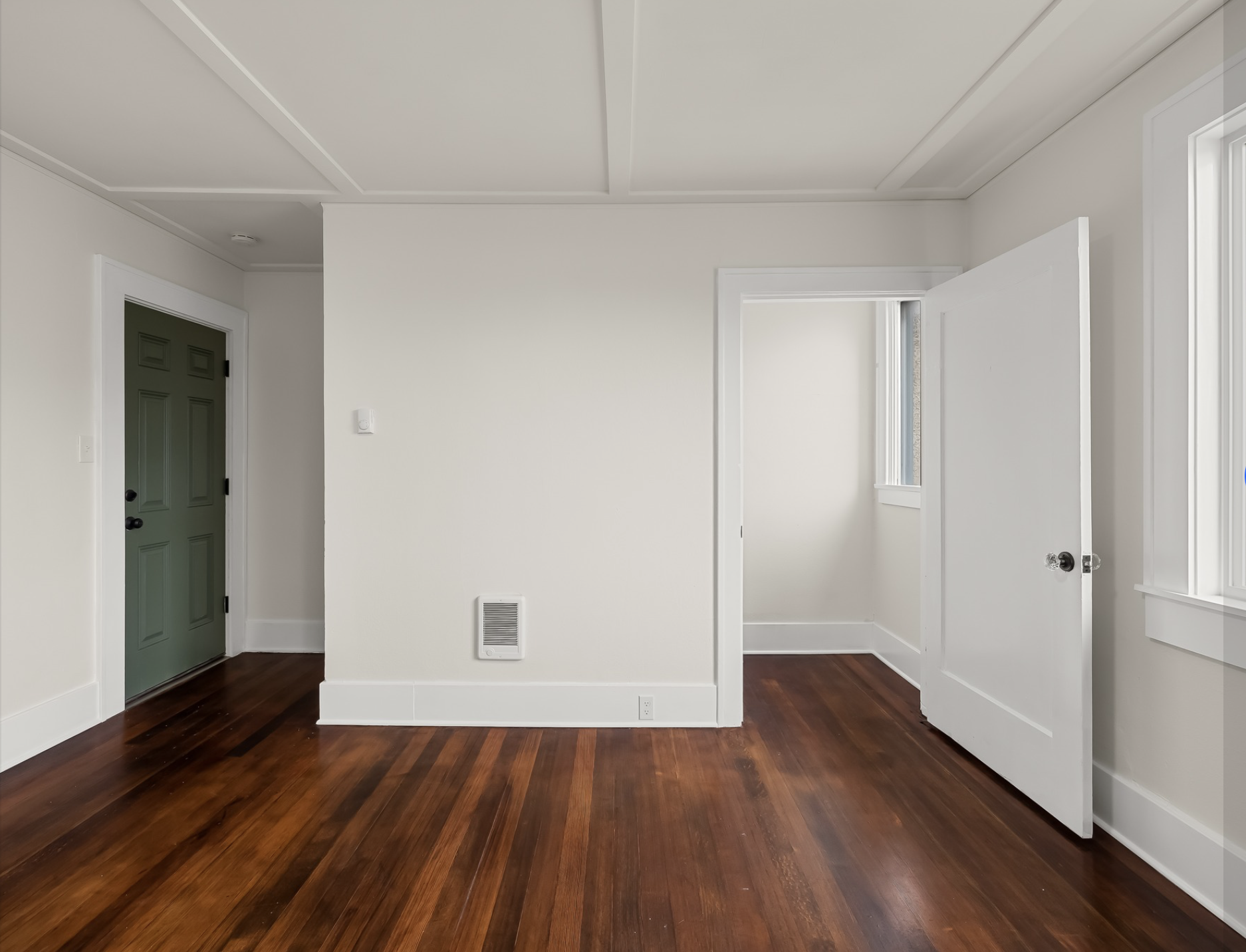 Mayflower Apartments — bedroom with refinished hardwood floors and green entry door